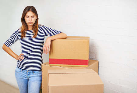 So much to do. Shot of an attractive young woman busy moving house.の写真素材