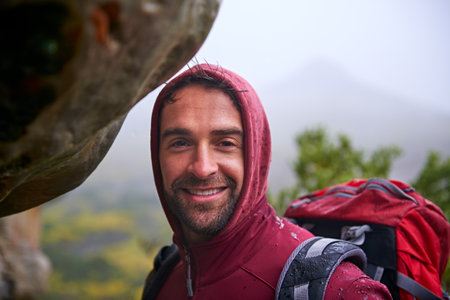 Looks like weve gotta go through. Shot of a young man enjoying a hike through the mountains.の写真素材