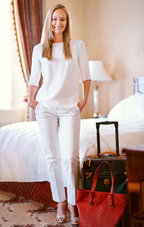 This hotel caters to my needs. Shot of an attractive young woman in her hotel suite.の写真素材