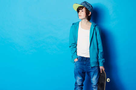 Skating dreams. A young boy holding his skateboard.の写真素材