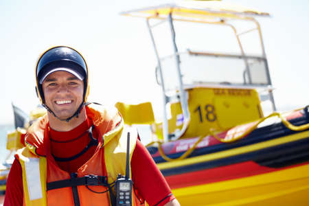 I love sea rescue. Cropped portrait of a handsome young male lifeguard preparing to go out to sea on a rescue mission.の写真素材