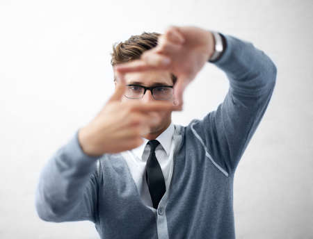 Hes got the vision to create something awesome. A young and trendy guy wearing spectacles while making a frame with his fingers.の写真素材