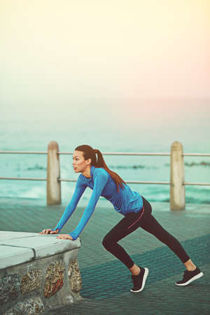 Running is a very physically demanding sport, therefor, stretch. Shot of a sporty young woman...