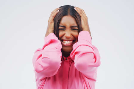 I cant take it anymore. Studio shot of an attractive young woman looking stressed out against a grey background.の写真素材