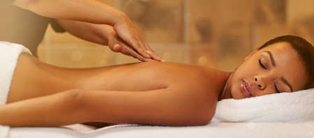 Enjoy a day of pampering. Cropped shot of a young woman getting a massage at the spa.の写真素材