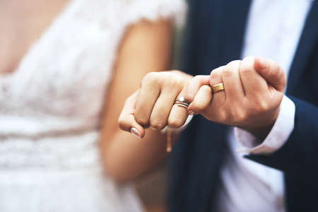 I pinky promise Ill be by your side forever. Cropped shot of an unrecognizable newlywed couple doing a pinky swear gesture on their wedding day.の写真素材