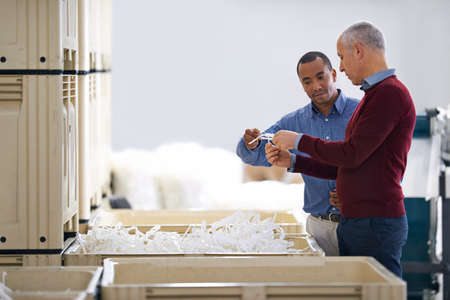 Stock control is vitally important. Shot of two factory managers doing an inspection of raw...