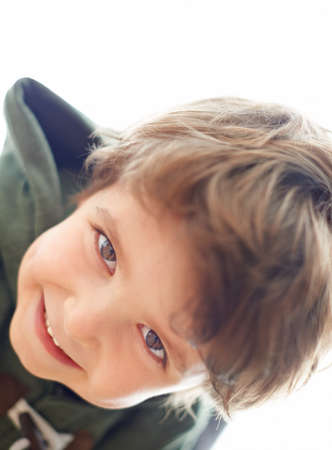Up to some mischief.... A young boy leaning over to look at the camera.
