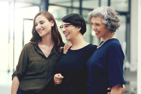 Just three talented and ambitious businesswomen. Shot of a group of businesswomen standing in an office.の写真素材