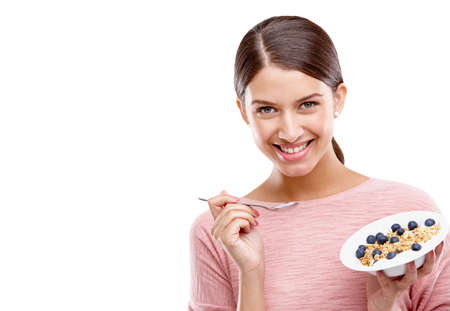 The best way to start a day. Studio portrait of a beautiful young woman eating a healthy breakfast.