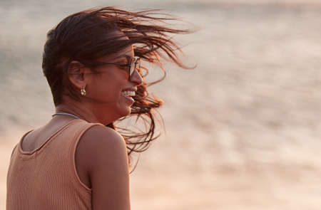 There are few things more cleansing than ocean air. Shot of a young woman enjoying the fresh beach...