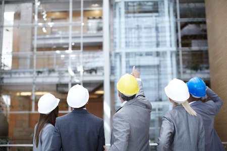 Can that be improved. A rearview shot of a diverse group of engineering professionals pointing up at...
