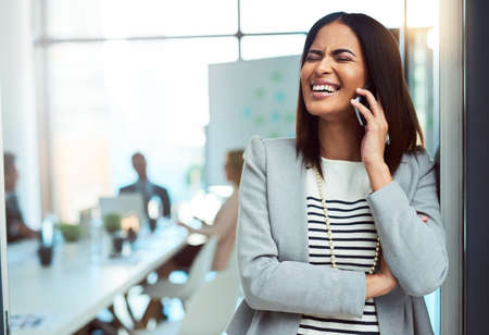 Who said there arent laughs in the corporate world. Cropped shot of a beautiful young businesswoman on a call in the workplace.の写真素材