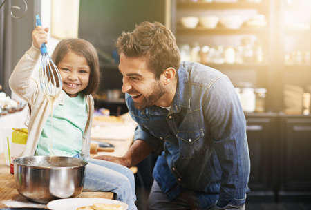 This is how you make the perfect pancake batter. Shot of a father and daughter making pancakes together.の写真素材