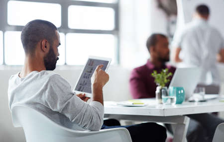 He takes his tablet into every meeting. Shot of a group of businesspeople meeting in the boardroom.