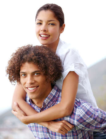 Strong enough for both of them. Shot of a handsome young man giving his girlfriend a piggyback outdoors.の写真素材