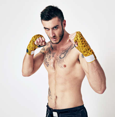 If you practice hard, you can win every battle. Shot of an MMA fighter in the studio.の写真素材