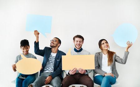 Sharing our opinions. Shot of a diverse group of creative employees holding up speech bubbles...