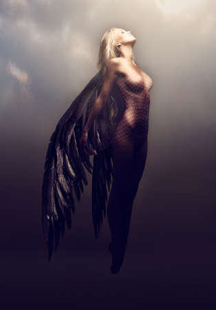 Watch her feminine splendor take flight. Shot of a gorgeous woman with feathered wings in a...