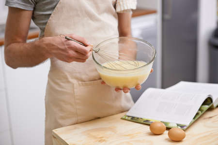 Its going to be the best omelette ever. Cropped shot of a young man cooking in the kitchen.の写真素材