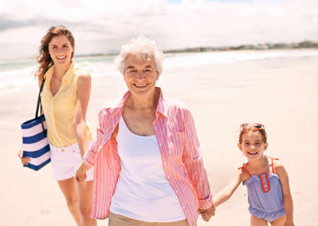 Three generations of wonderful women. Portrait of a grandmother with her daughter and granddaughter at the beach.の写真素材