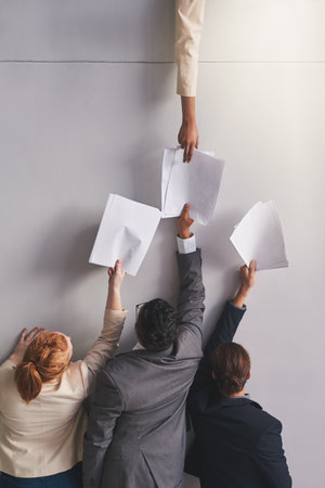 You requested these documents.... Cropped shot of businesspeople handing documents to a colleague in an office.の写真素材