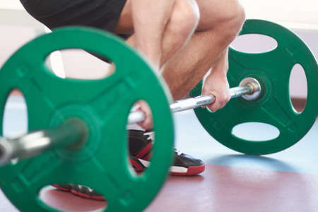 Pain is temporary, pride is forever. Cropped shot of a man working out with weights in the gym.