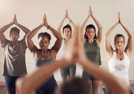 The zen is in the air. Shot of a group of young people working out together in a yoga class.の写真素材