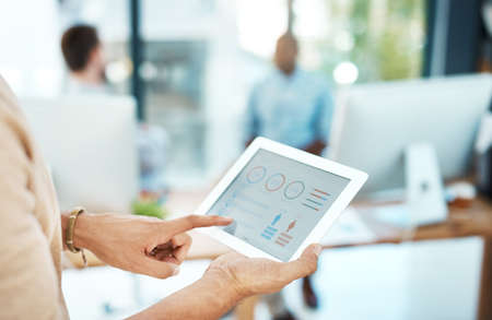 Always up-to-date with the latest software. Cropped shot of a businesswoman using her digital tablet...