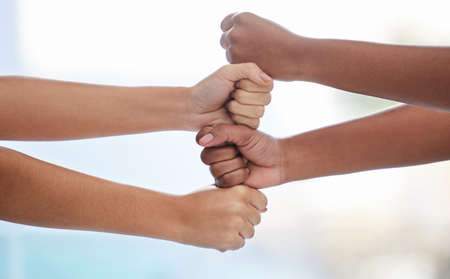 Our strengths combined lead to an unbreakable bond. Closeup shot of two unrecognisable women stacking their fists together.の写真素材