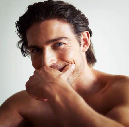 You could lose yourself in his eyes. Portrait of a handsome man with his hand covering his mouth.の写真素材