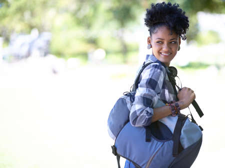 Cool and casual on campus. An attractive young college student standing outdoors.の写真素材