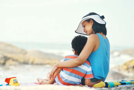 I wish I could freeze time in this moment. Shot of s mother and son sitting on the beach looking at the view.の写真素材