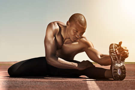 His dedication is formidable. An athlete stretching.