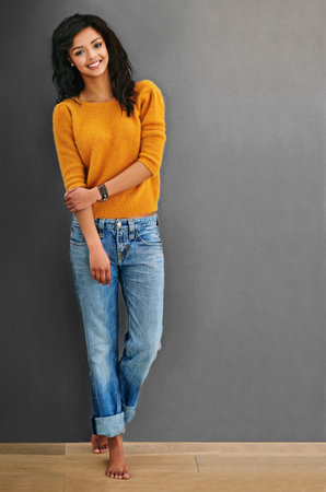 Its the simple things in life that make me smile. Studio shot of an attractive young woman posing against a gray background.の写真素材
