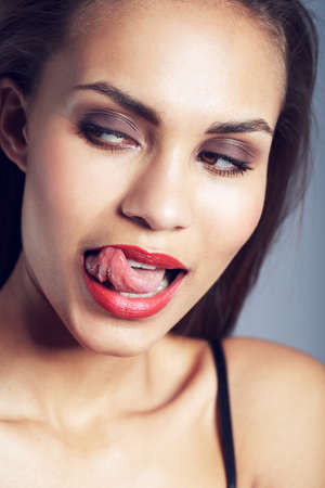 Somethings got her interest. Studio shot of a gorgeous young woman posing against a gray background.の写真素材