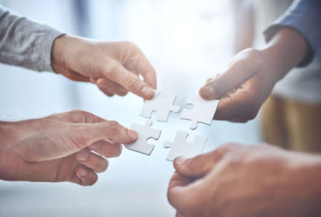 We can solve anything as a team. Closeup shot of a group of unrecognisable businesspeople holding...