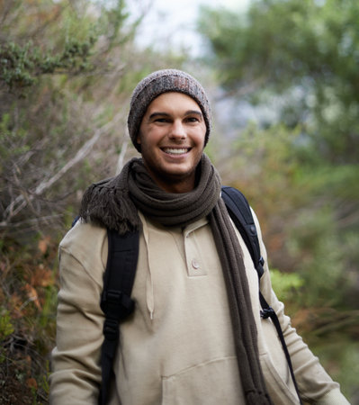He loves getting in touch with nature. Portrait of a handsome young man hiking in the mountains.