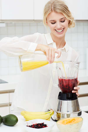 Juicing is both healthy and nutritious. A beautiful young woman making a healthy shake with her...