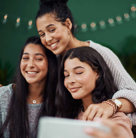 You cant break that special bond of sisters. Shot of young sisters taking selfies together at a cafe.の写真素材
