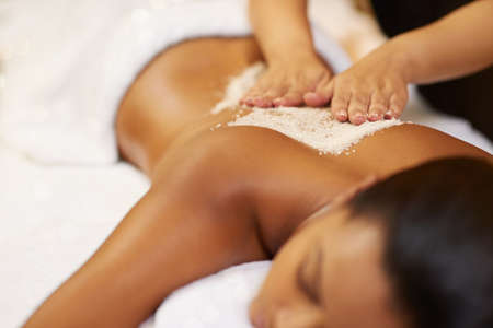 When in doubt massage it out.... Cropped shot of a young woman getting an exfoliating treatment at the spa.の写真素材
