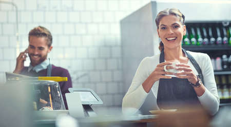 No one knows coffee like we do. Portrait of a young woman having coffee in a store while her...