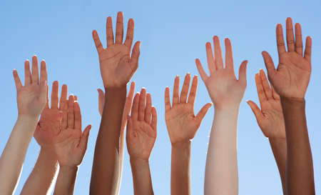 Solidarity through diversity. Cropped shot of a diverse group of people raising their hands.