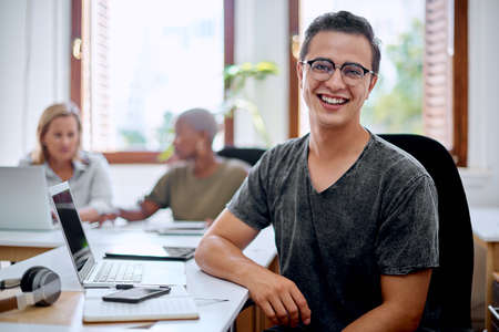 Youll learn lots by showing dedication. Portrait of a young businessman working in an office.の写真素材