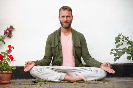 Mind over matter. Portrait of a handsome mature man doing yoga in an outside courtyard.の写真素材