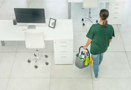 Shell clean it all with one call. High angle shot of a woman cleaning a modern office.の写真素材