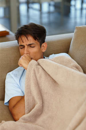 No more staying out late for me. Cropped shot of a young man coughing.