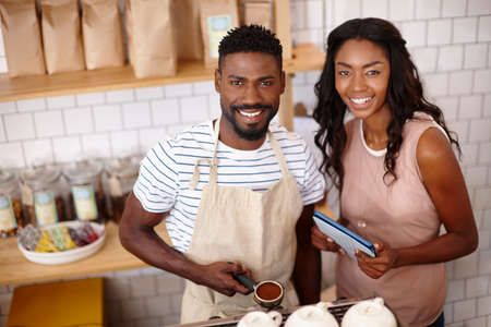 Connecting with some coffee. Portrait of a bistro owner using a digital tablet.の写真素材