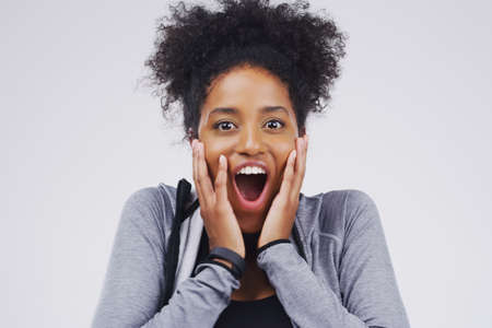 What a surprise. Studio portrait of an attractive young woman looking surprised against a grey background.の写真素材