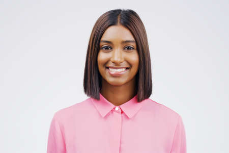 Im the happiest version of me. Studio portrait of an attractive young woman smiling against a grey...